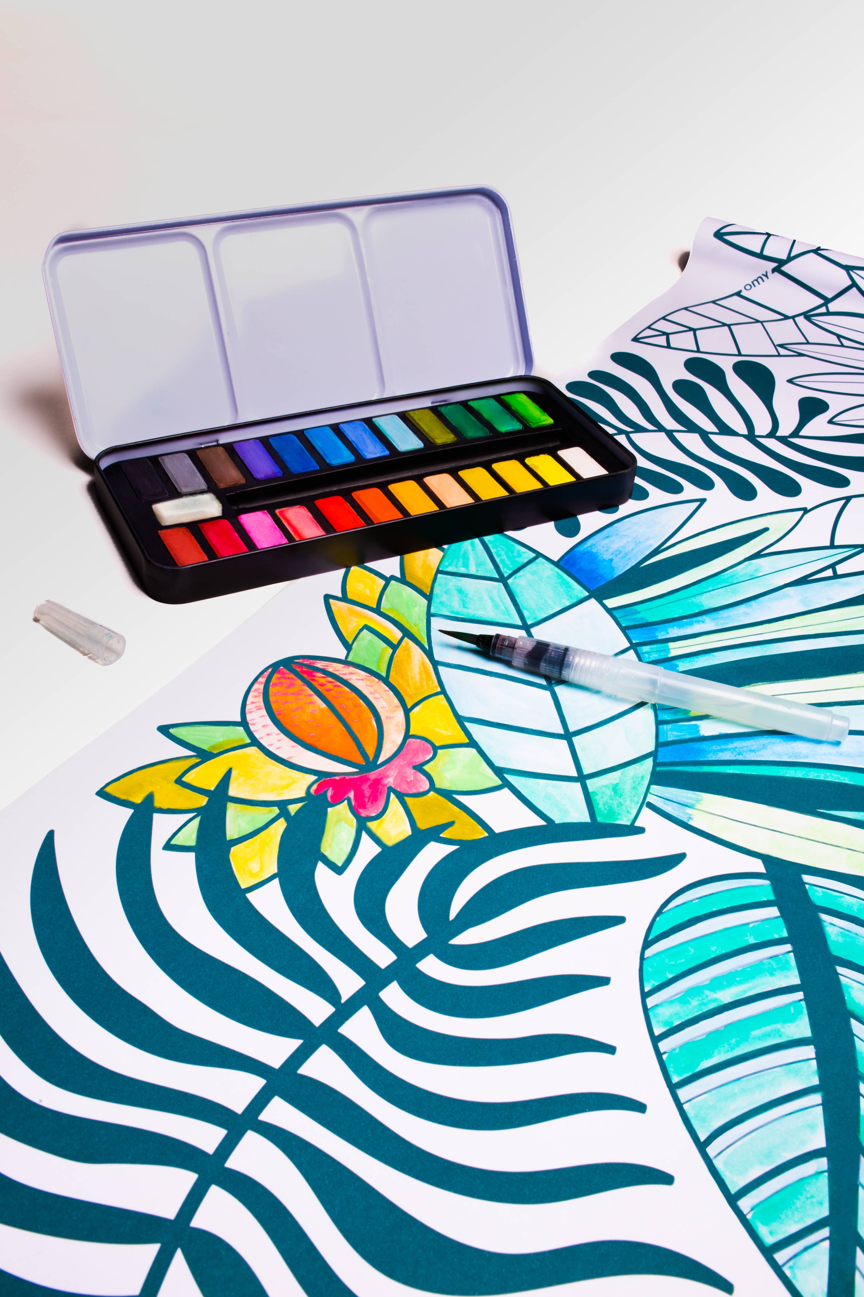 Watercolor paint kit featuring drawing of flower, paintbrush, and palette. Ideal for art exploration on paper, cardboard, or canvas. Portable and beginner-friendly with water brush compartment.