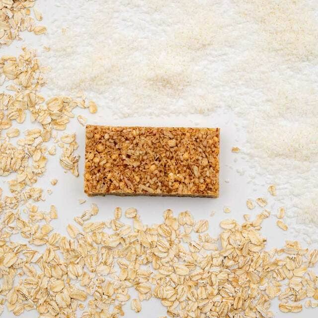 Organic Lemon Coconut & Ginger Bivy Bar with oats and a cracker close-up. Gluten-free, non-GMO, USDA-certified. Nutritious fuel for adventures.