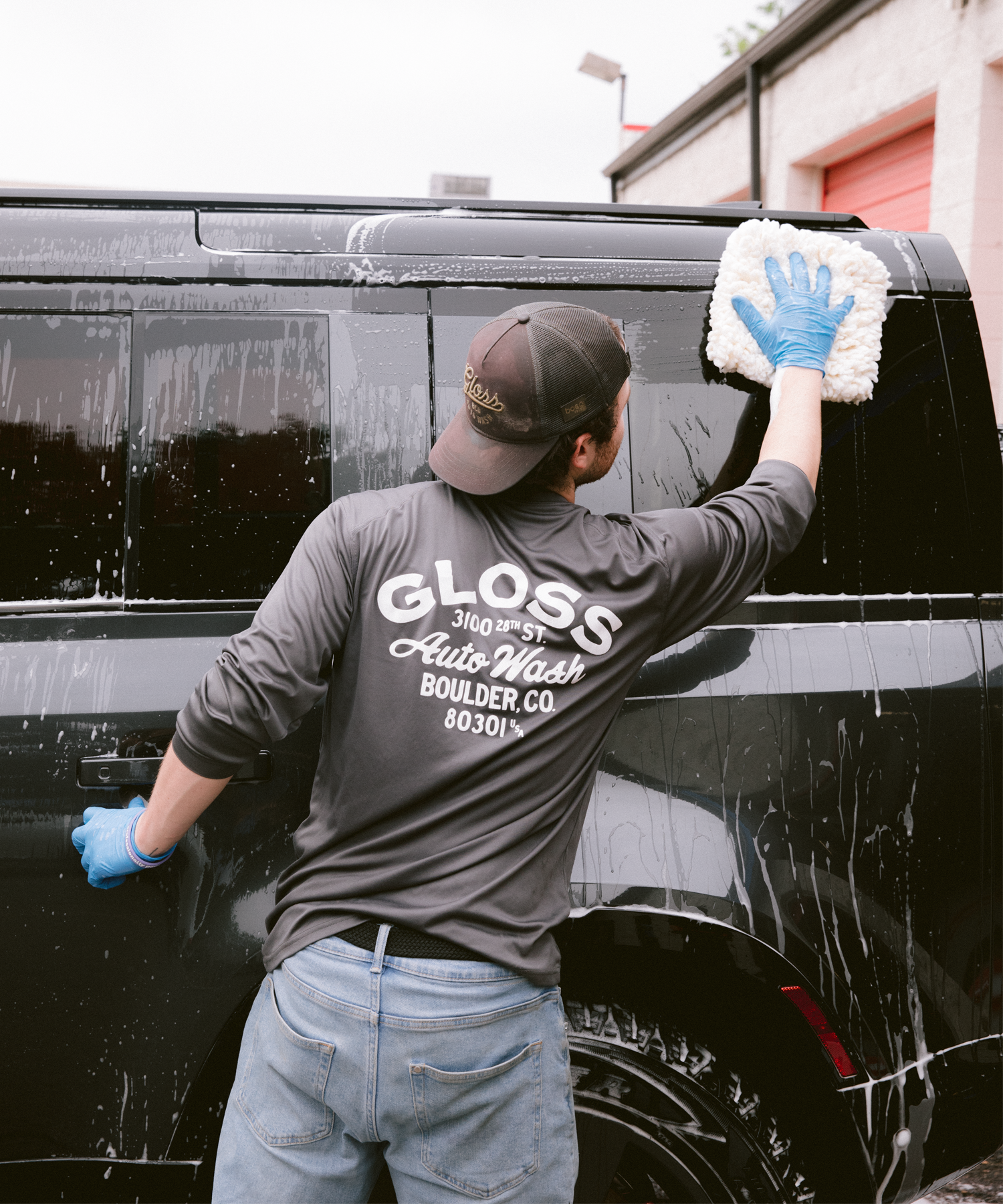 A man hand washing a car, focusing on detailing wheels, tires, and interior. Utilizes two bucket method, microfiber towels, and compressed air for drying. Vacuuming and dusting included.
