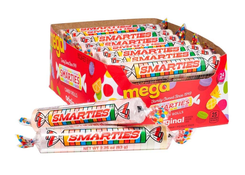 A box containing multiple rolls of Smarties Mega Roll, 2.25oz Pop, 24ct Case, with three Smarties rolls placed in front. The red box, decorated with colorful fruit images and featuring the "mega" and "Smarties" branding from Grandpa Joe's Candy Shop, evokes nostalgia. Each roll is wrapped in clear plastic and perfect as a Halloween treat.