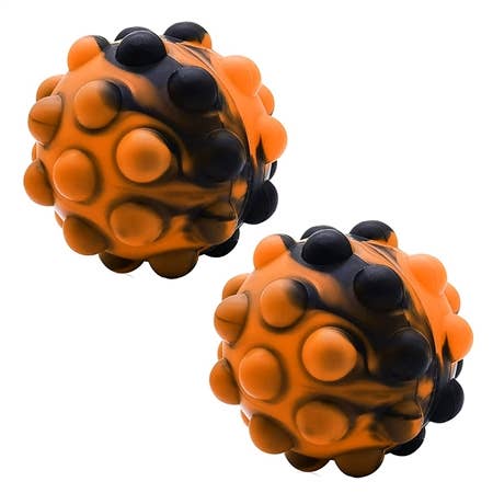 Top Trenz Inc. - OMG 3D Pop Fidgety Ball - Halloween Edition: A pair of rubber balls with a cartoon design, close-up shots showcasing the 3D glitter texture.