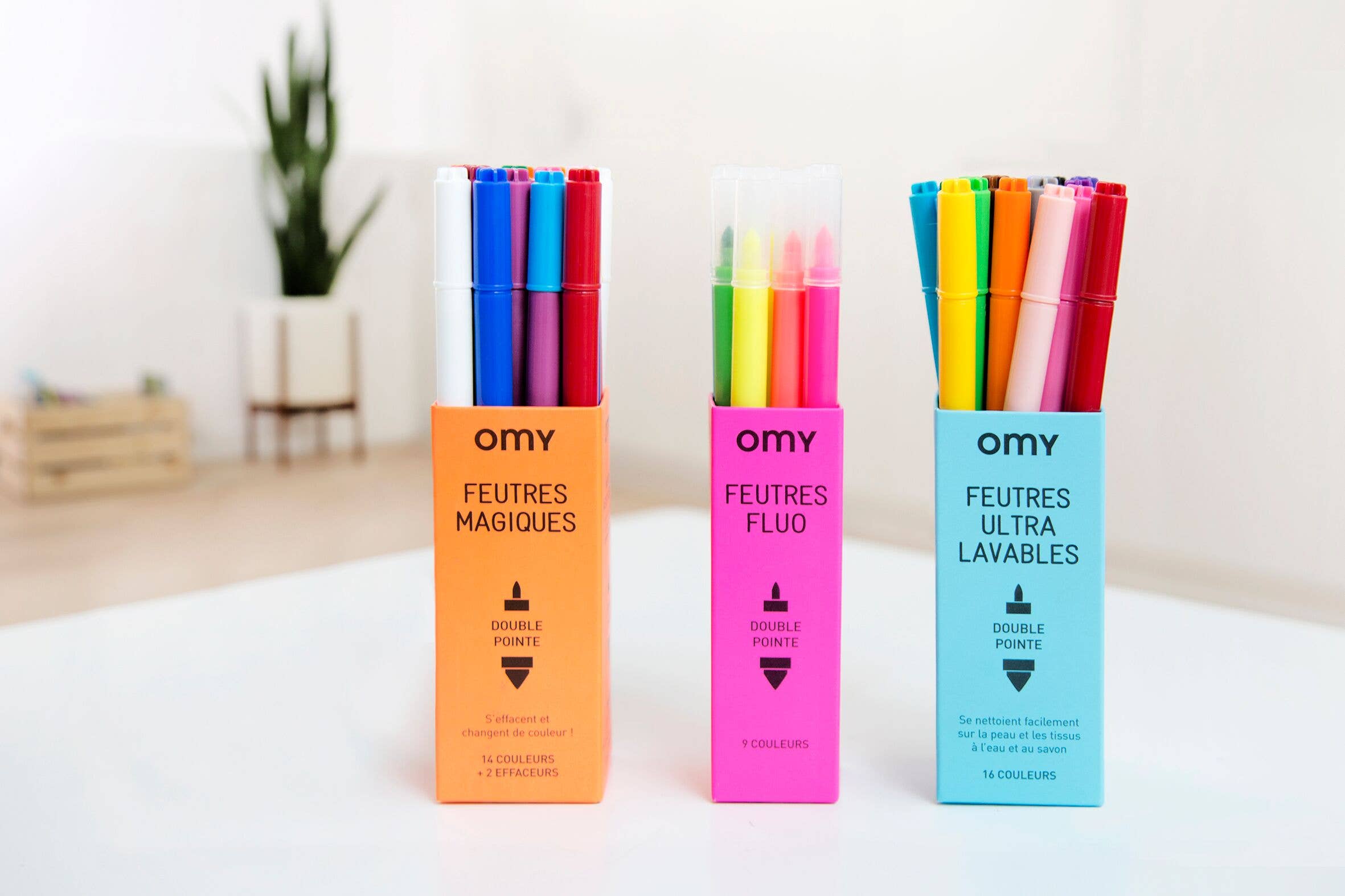 A group of 16 magic markers in a box, ready for colorful creations. White marker transforms colors to cap hues. Ideal for artistic expression.