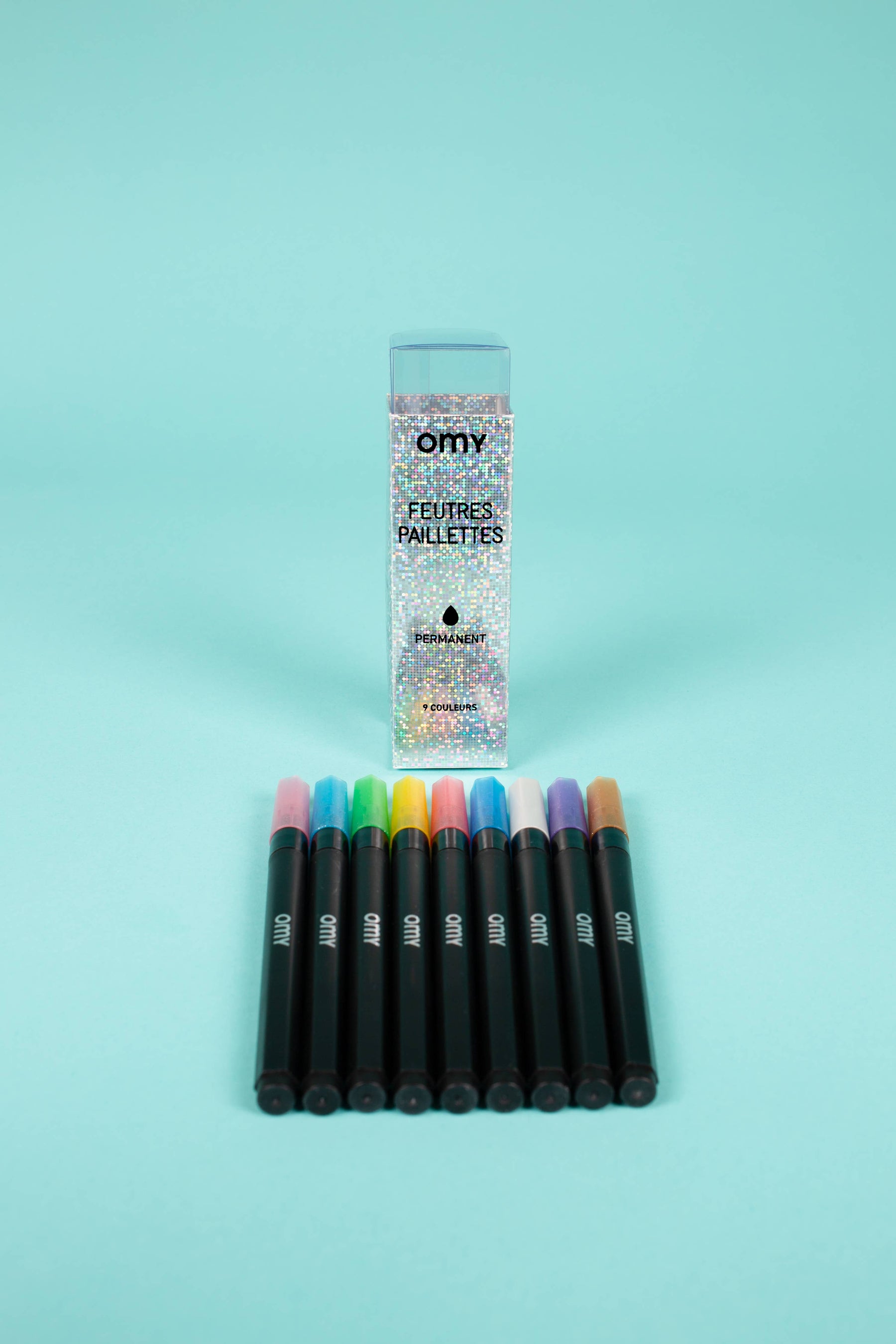 A group of colorful markers next to a box of glittery pens, featuring 9 Glitter Markers in shimmering colors for vibrant drawings. Waterproof and sunproof, press down for glitter effects.
