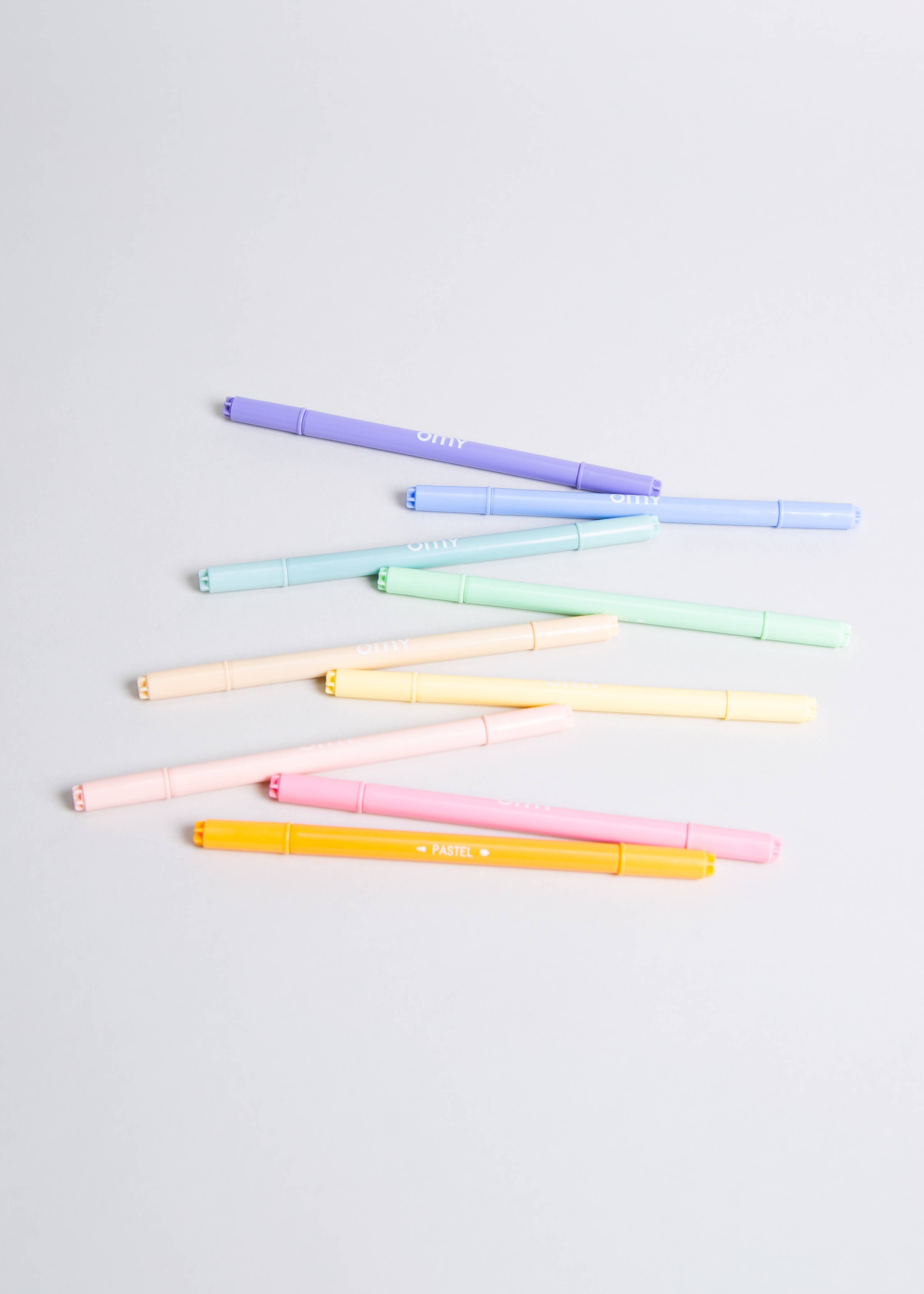 A group of dual tip pastel markers in various colors, including yellow, pink, and purple, showcasing their versatility and vibrant hues. The markers come in a box that doubles as a holder, adding convenience to your creative endeavors. Made in Italy.