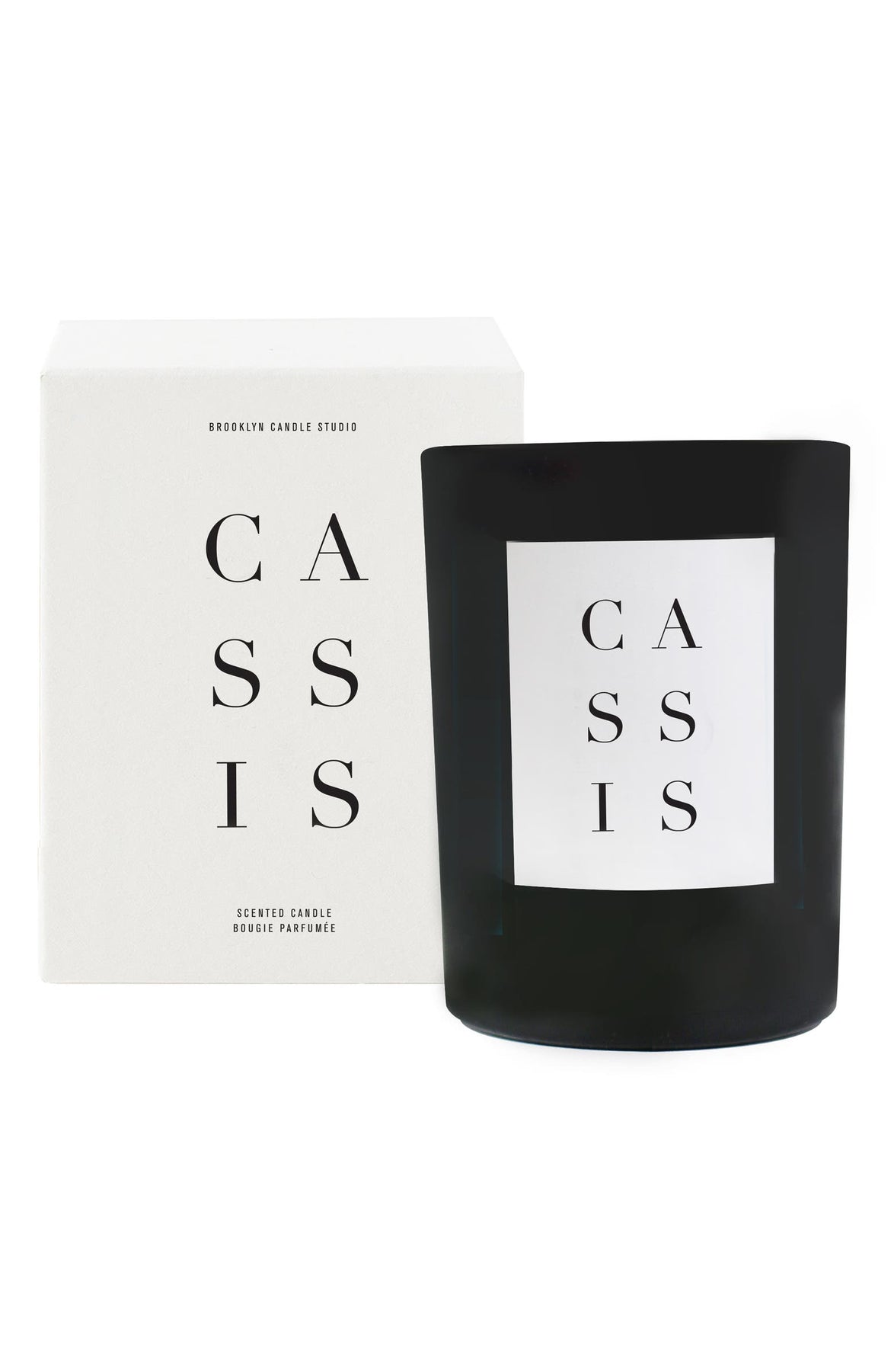 Hand-poured Cassis Candle in black matte glass vessel, packaged in textured box. Features black currants, red berries, and wild rose scent. 100% soy wax, cotton wick, up to 70-hour burn time.