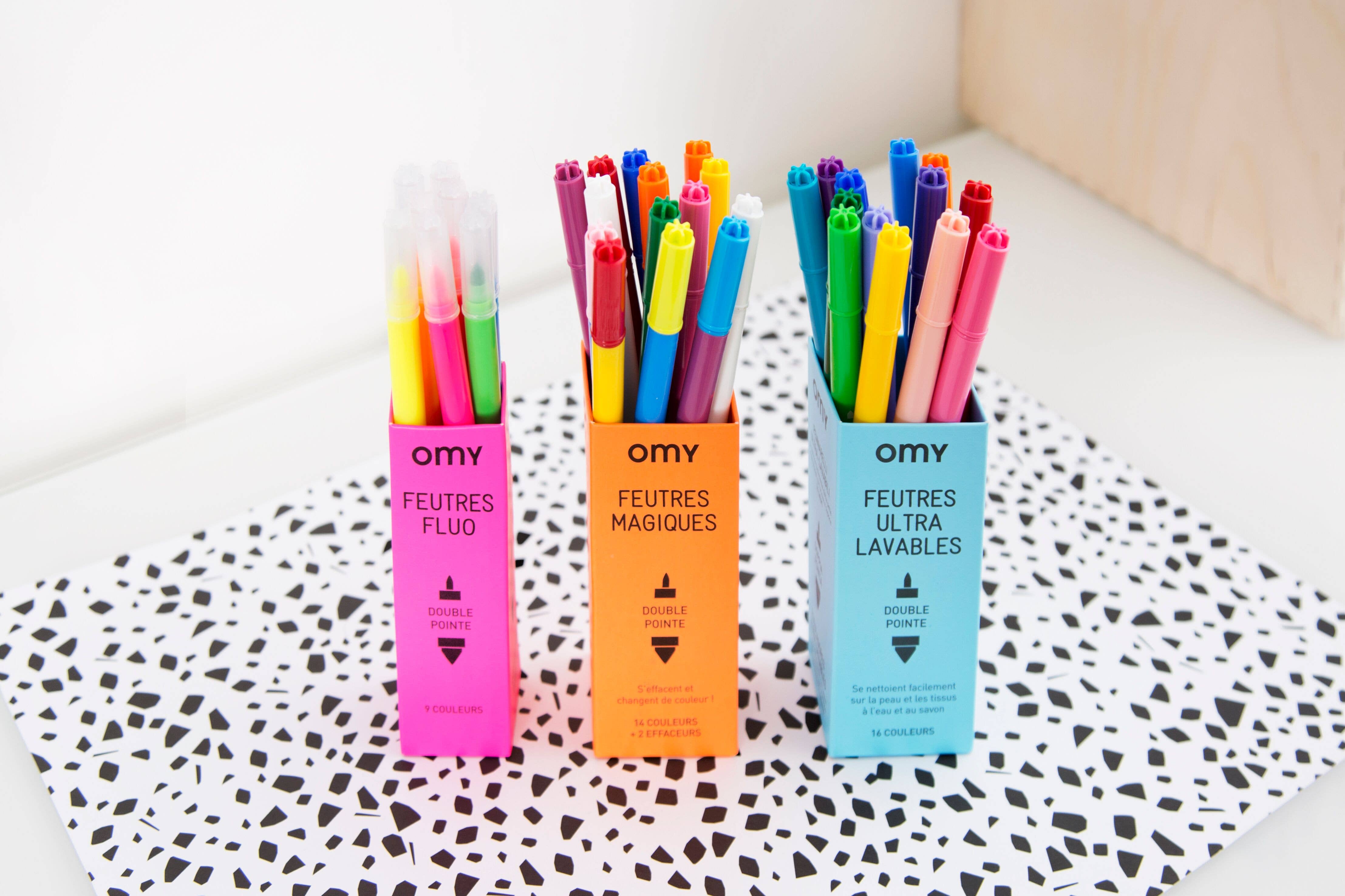 A box of 16 magic markers for colorful creations. White marker changes colors to cap hues. Ideal for artistic expression.
