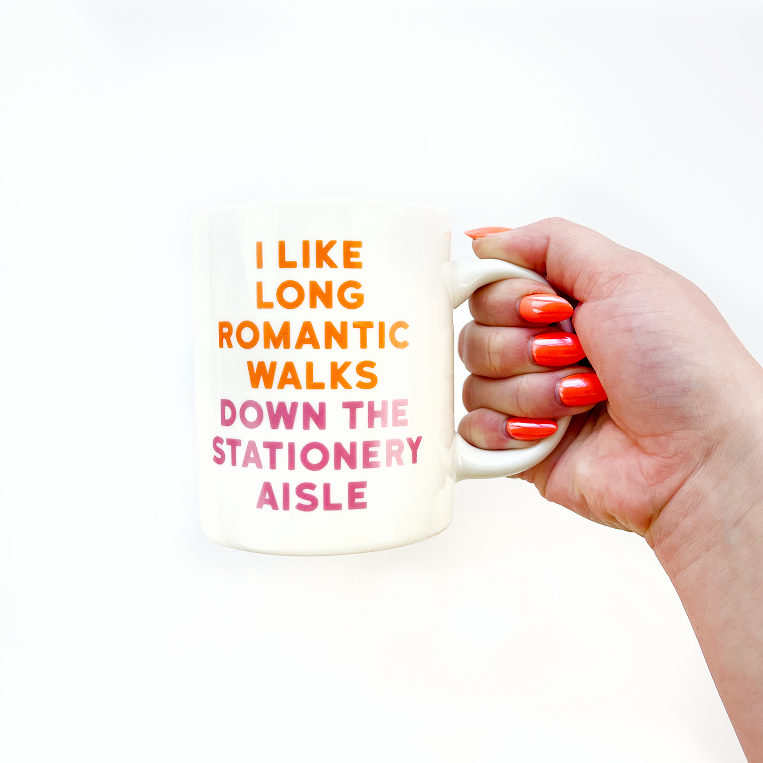 A hand holds a white mug with stationery-themed design, showcasing Pipsticks Stationery Aisle Mug and a matching vinyl sticker. Crafted for sticker enthusiasts, microwave and dishwasher safe, 11oz. capacity.