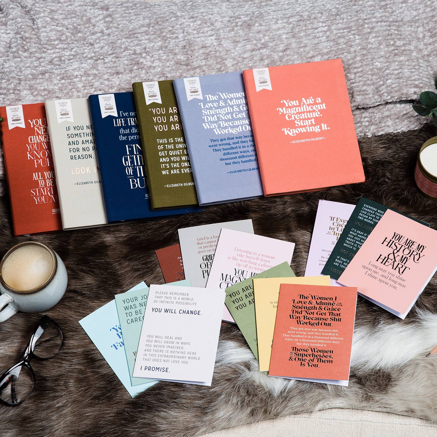 A cloth-covered Elizabeth Gilbert Gorgeous and Amazing Journal on a fur rug, featuring foil stamping, 160 lined pages, and a ribbon marker.