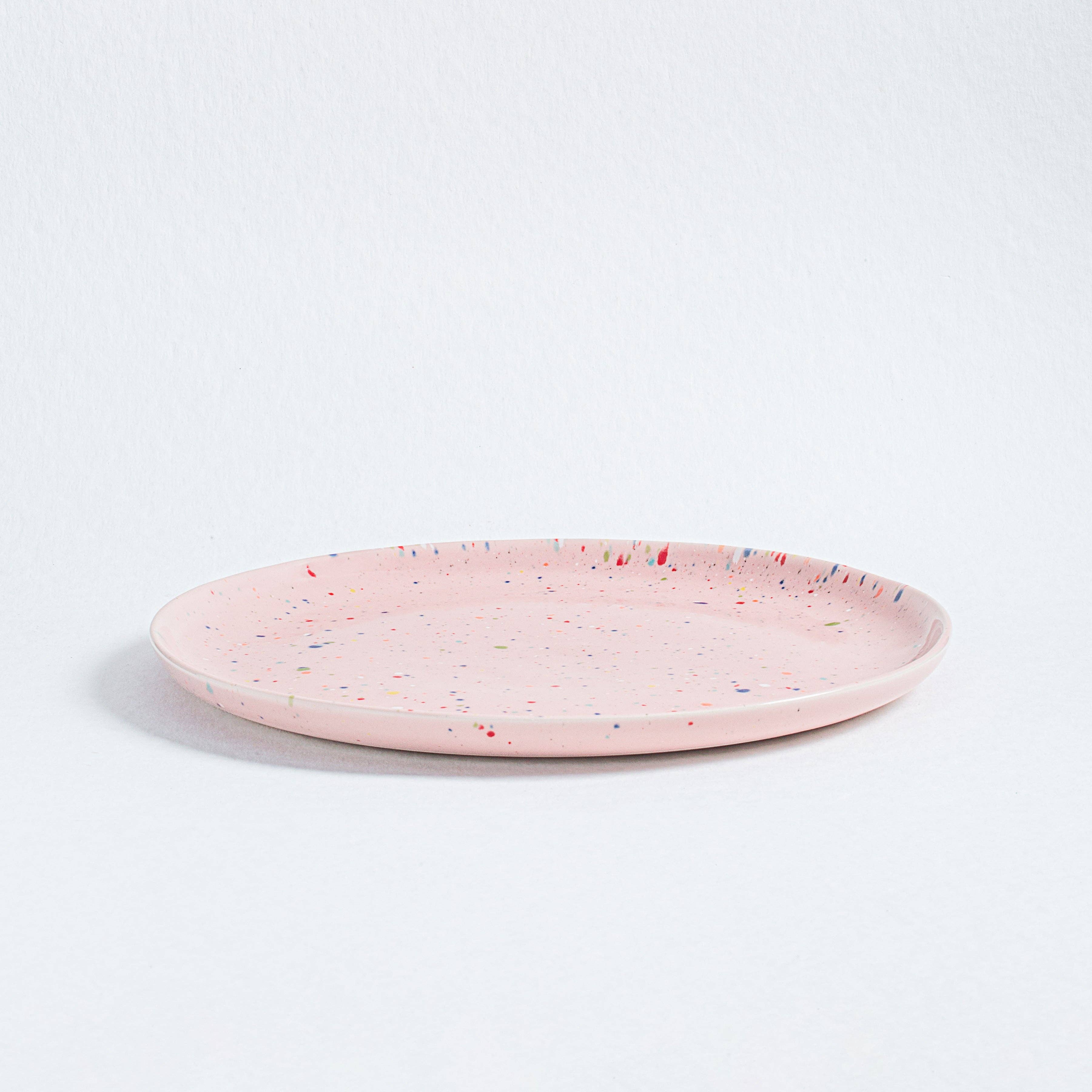 Artisanal Party Dinner Plate in pink, speckled ceramic design, 27.5cm diameter, 2cm height. Vibrant and unique, dishwasher and microwave safe, food safe, cadmium-free. Celebrate individuality with each piece.