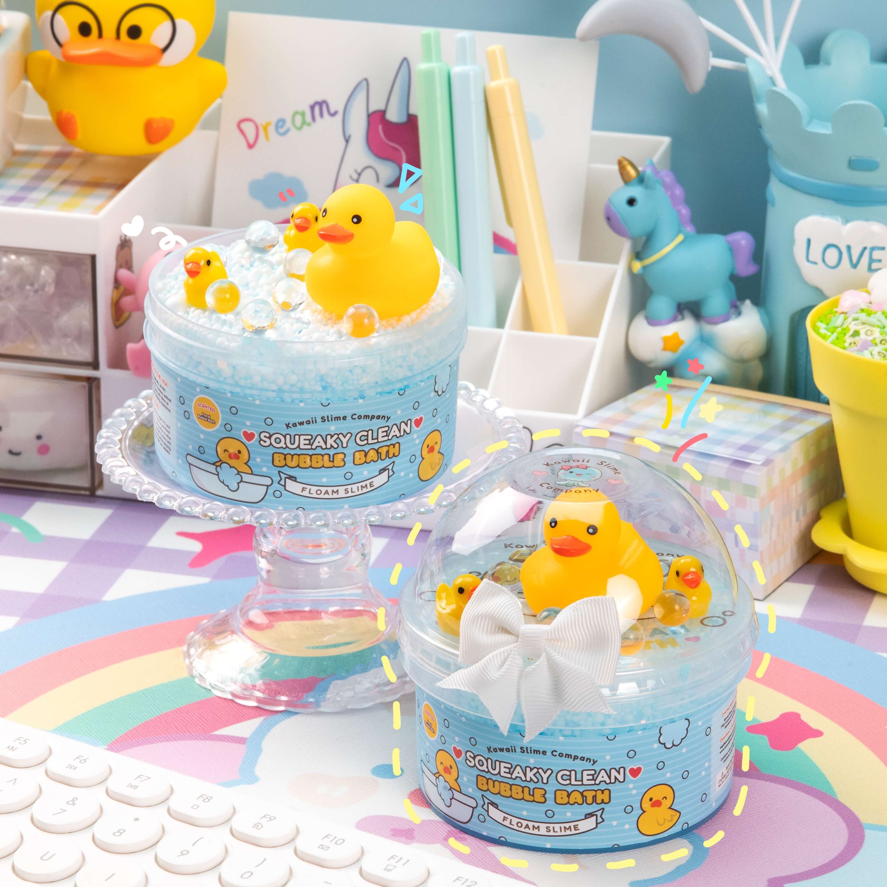 A clear container holds Squeaky Clean Bubble Bath Floam Slime with foam beads, glitter, and a squeaky duck toy. Floral-scented for a fun bath time experience.