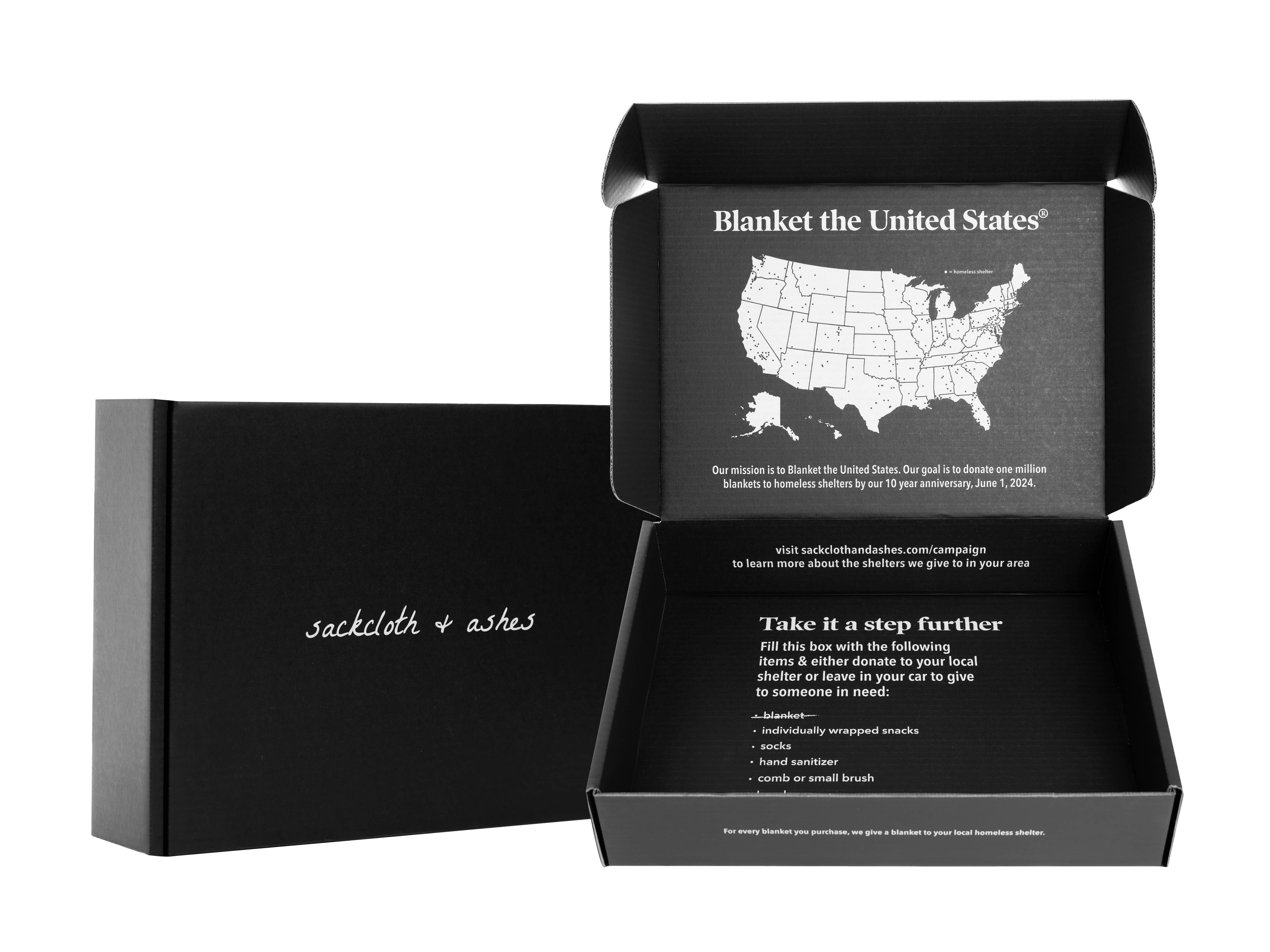 A black box featuring a map of the United States, part of the Mountain Arctic blanket collection. Sustainable materials, 70”l x 60”w size, and a commitment to donate blankets to local shelters.