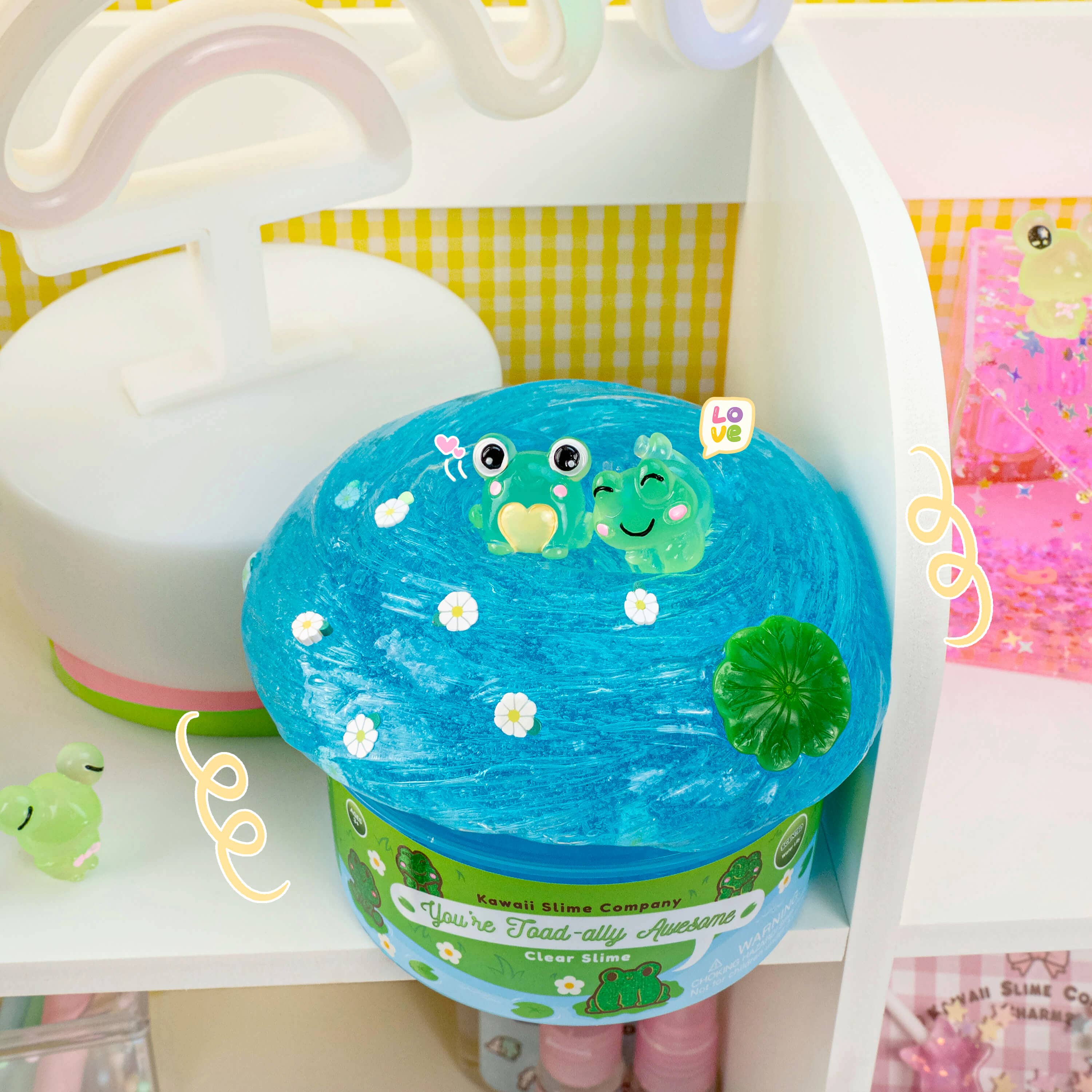 Clear slime with two toad charms, resembling a blue frog pond. Stretchy texture for playful pokes and bubble pops. Water lily scented for a refreshing experience.