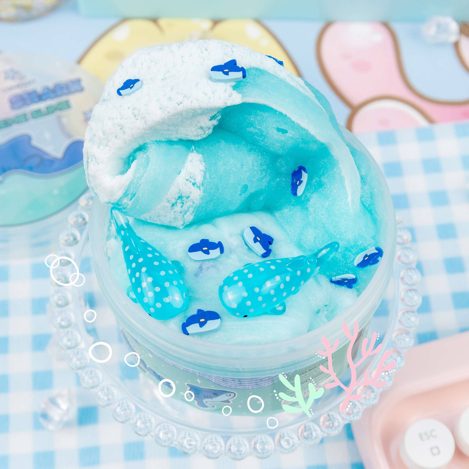 A blue and white Gummy Shark Jelly Creme Slime with shark fimo slices and whale shark charms, creating hypnotic swirls reminiscent of sea foam.