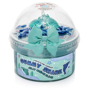 A blue jelly slime with shark fimo slices, white meringue swirls, and whale shark charms. Hypnotic swirls resembling sea foam, scented with blue raspberry and marshmallow cream.