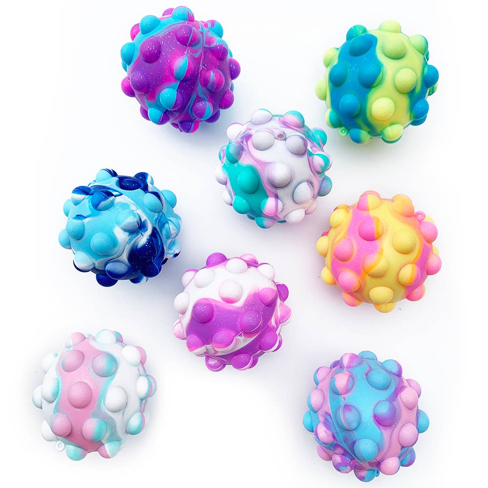 Colorful group of OMG Pop Fidgety 3D glitter balls, including blue, pink, purple, and white variations. Perfect for stress relief and portable play.