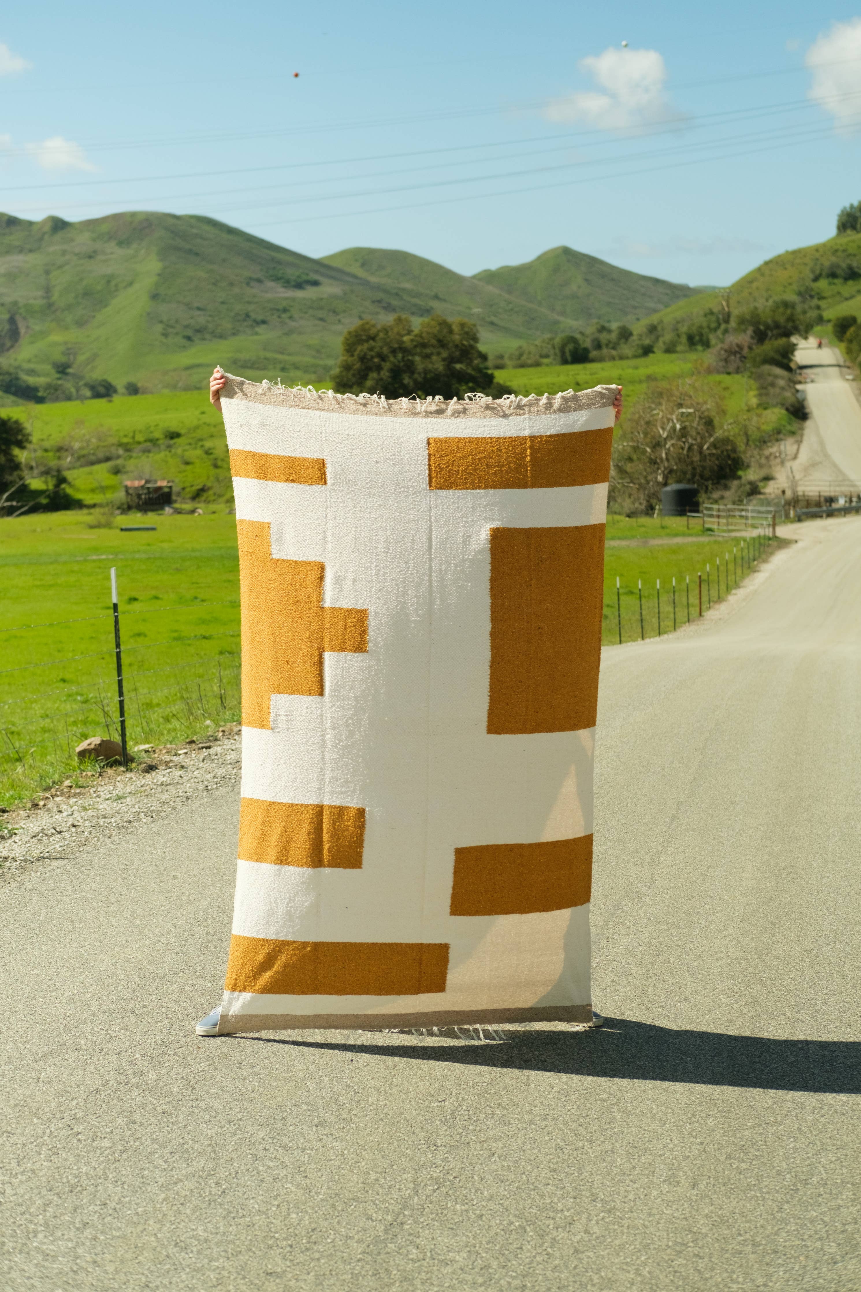 Handmade heavyweight blanket in Gold & Cream design, perfect for home or outdoor use. Measures 83 x 52 inches, sustainably crafted from reclaimed fibers.