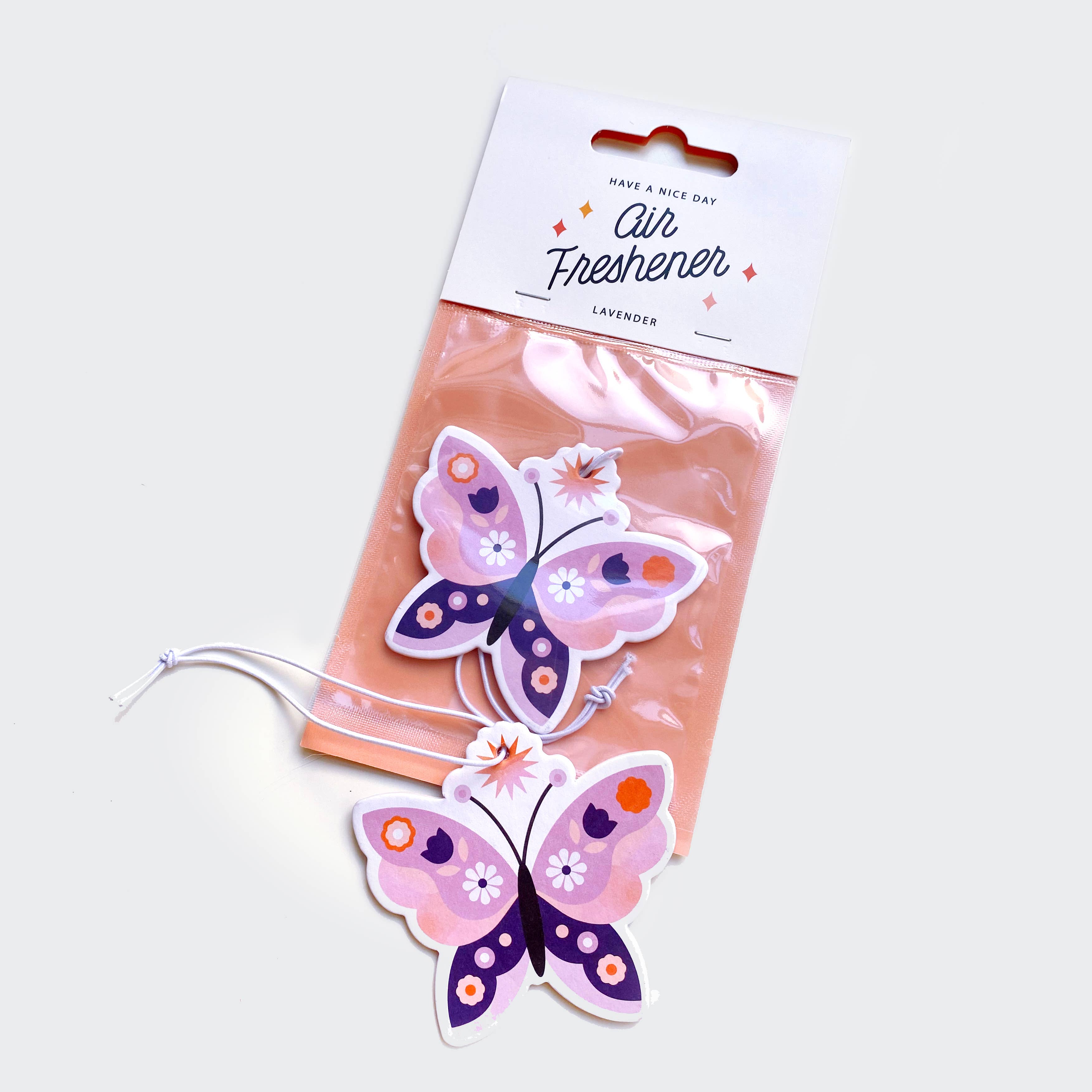 A butterfly-shaped lavender-scented air freshener, 3.25in x 3.5in, double-sided print, in packaging, with floral tag and string.