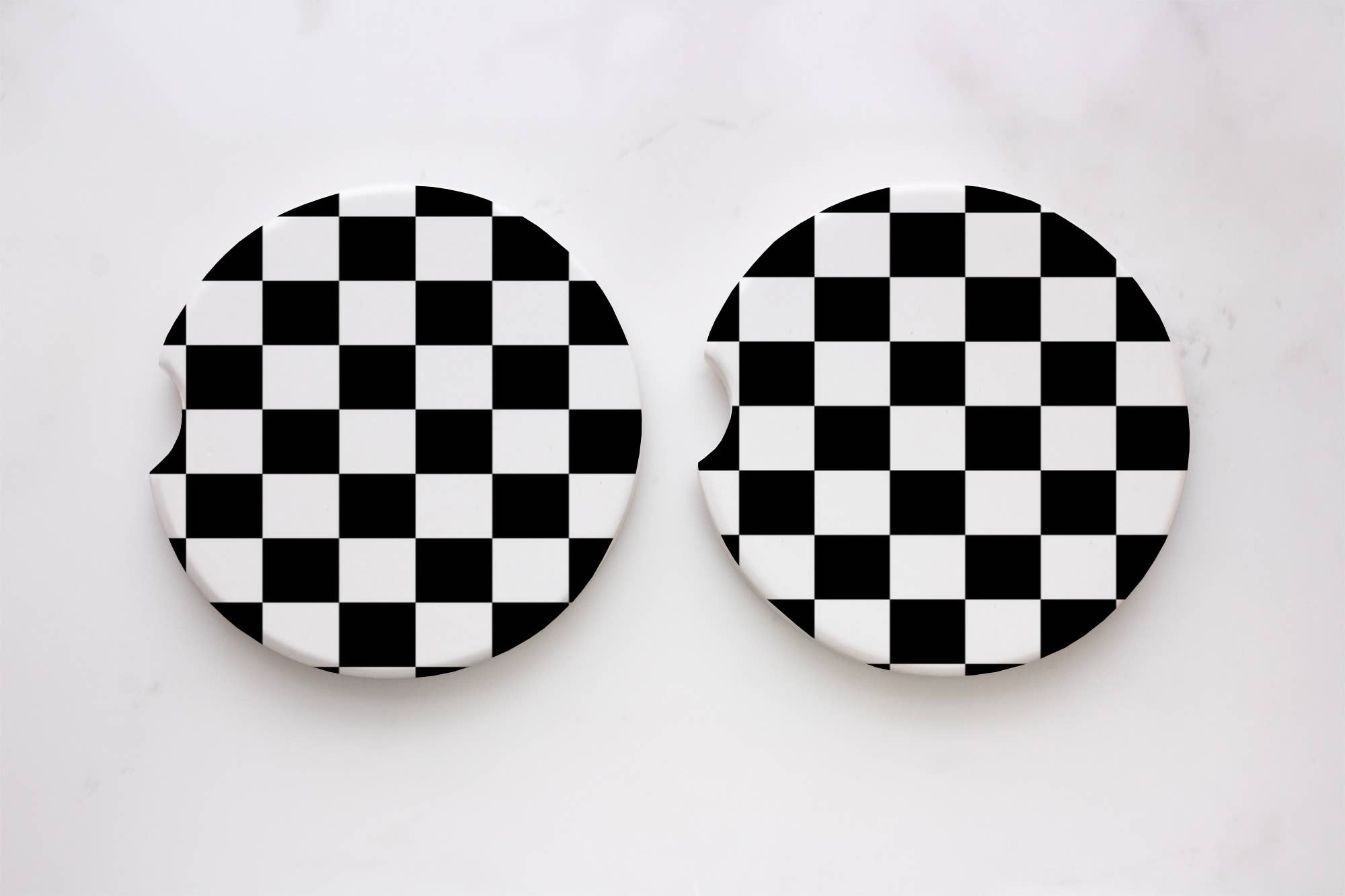 A pair of black checkered car coasters, 2.6 x 0.125, absorbent neoprene material with durable print. Packaged on car coasters card.