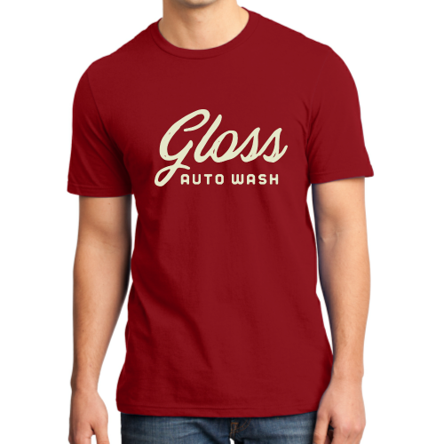 A man in a red shirt showcasing the Gloss Script T-Shirt Red, a casual active top with a white text sign in the background.