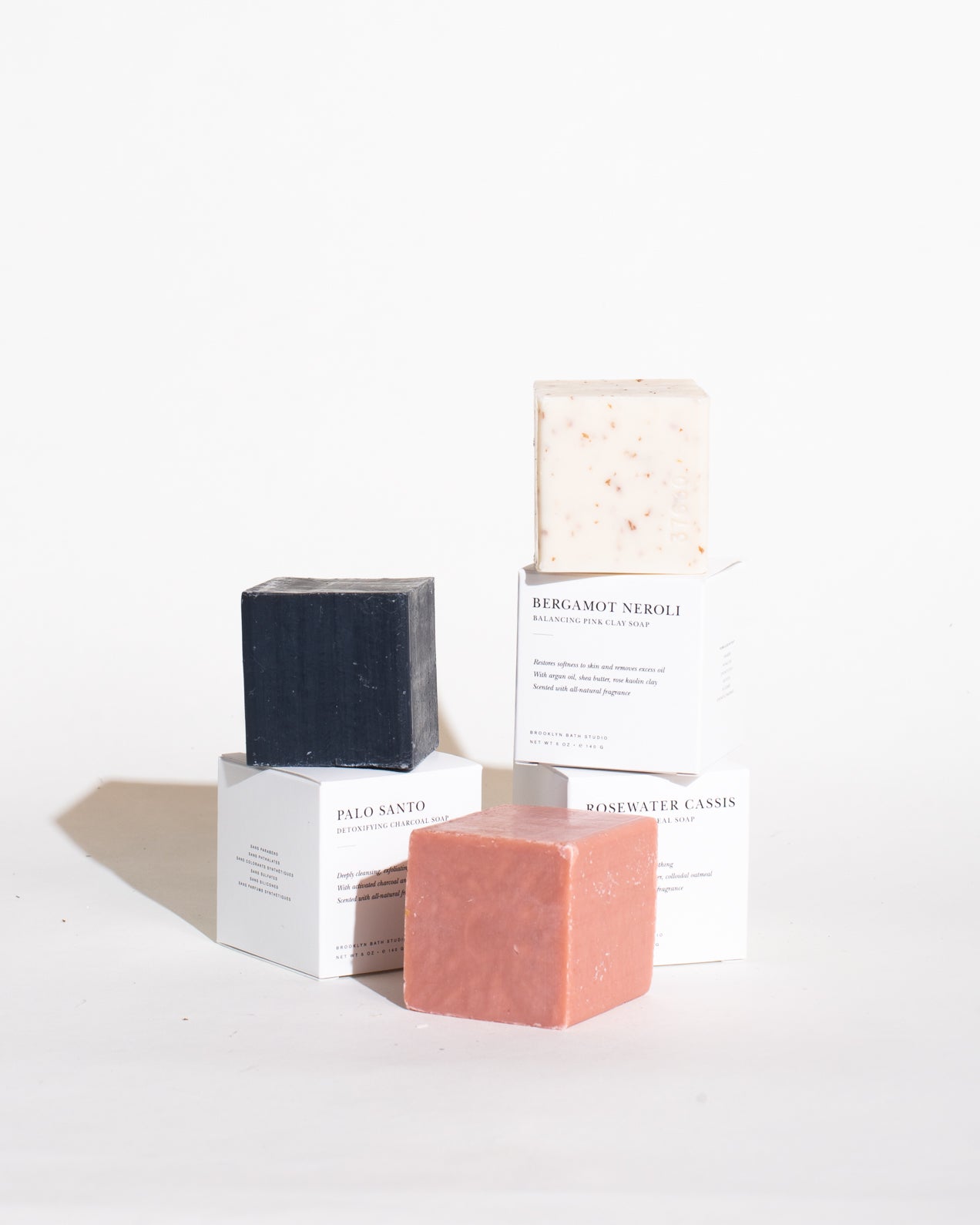 A chic cube of Palo Santo Bar Soap in minimalist packaging, featuring activated charcoal, jojoba oil, and bamboo powder for skin nourishment. A blend of cedar, peppermint, and eucalyptus essential oils.