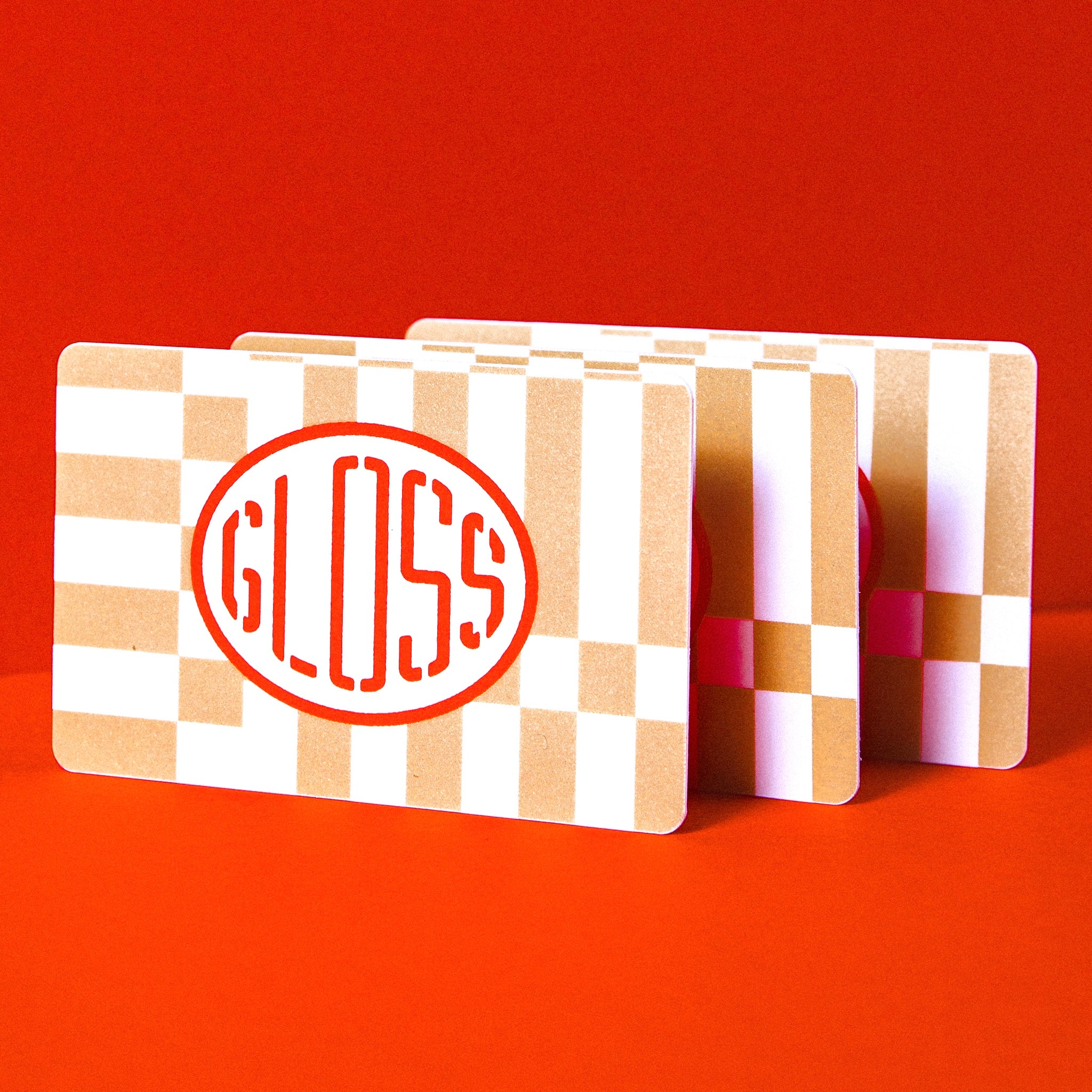 A close-up of a deck of cards featuring a red and white circle with text, a colorful square, and a red letter s on a white background. Product: Gift Card for a car wash.