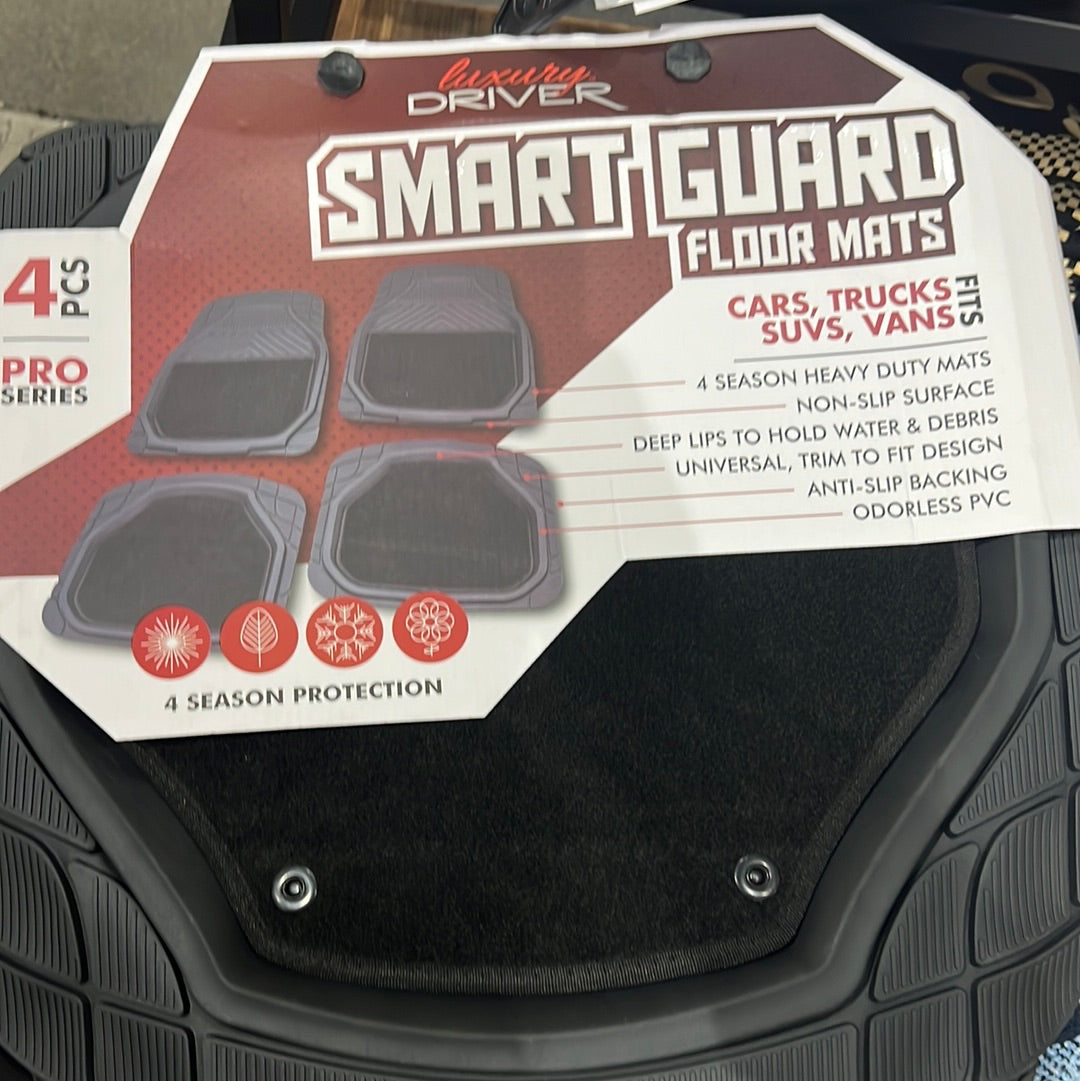 Close-up of SmartGuard 4 Piece Pro w/ Carpet - Black floor mats with a white label, ideal for cars. Durable auto part for vehicle protection.