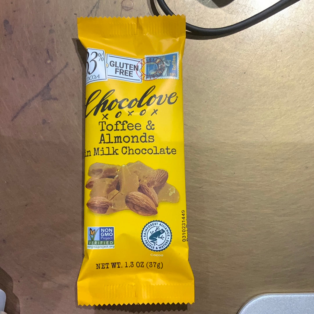 A yellow Chocolove Toffee & Almonds Milk Chocolate package with almonds, a candy bar, and a logo on a yellow surface.