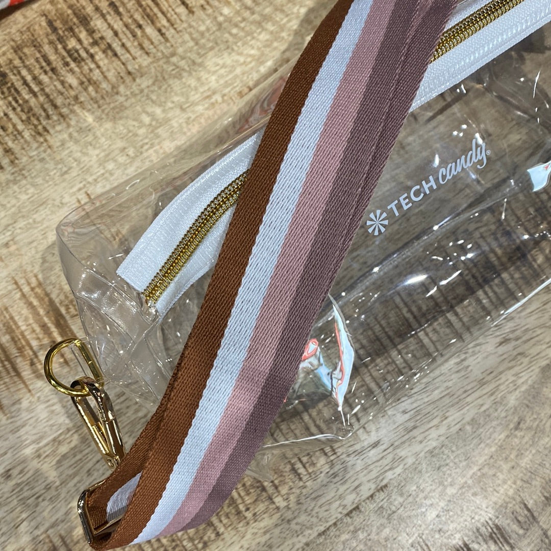 A clear stadium bag with a brown and white stripe guitar strap, designed for compliance with regulations. Water-resistant, adjustable strap, spacious for essentials. Dimensions: 10 x 5.75.