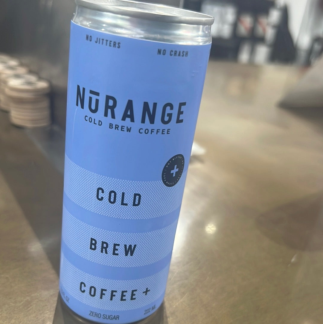 A close-up of Nurange cold brew coffee can on a table, showcasing a blue beverage container with a logo.