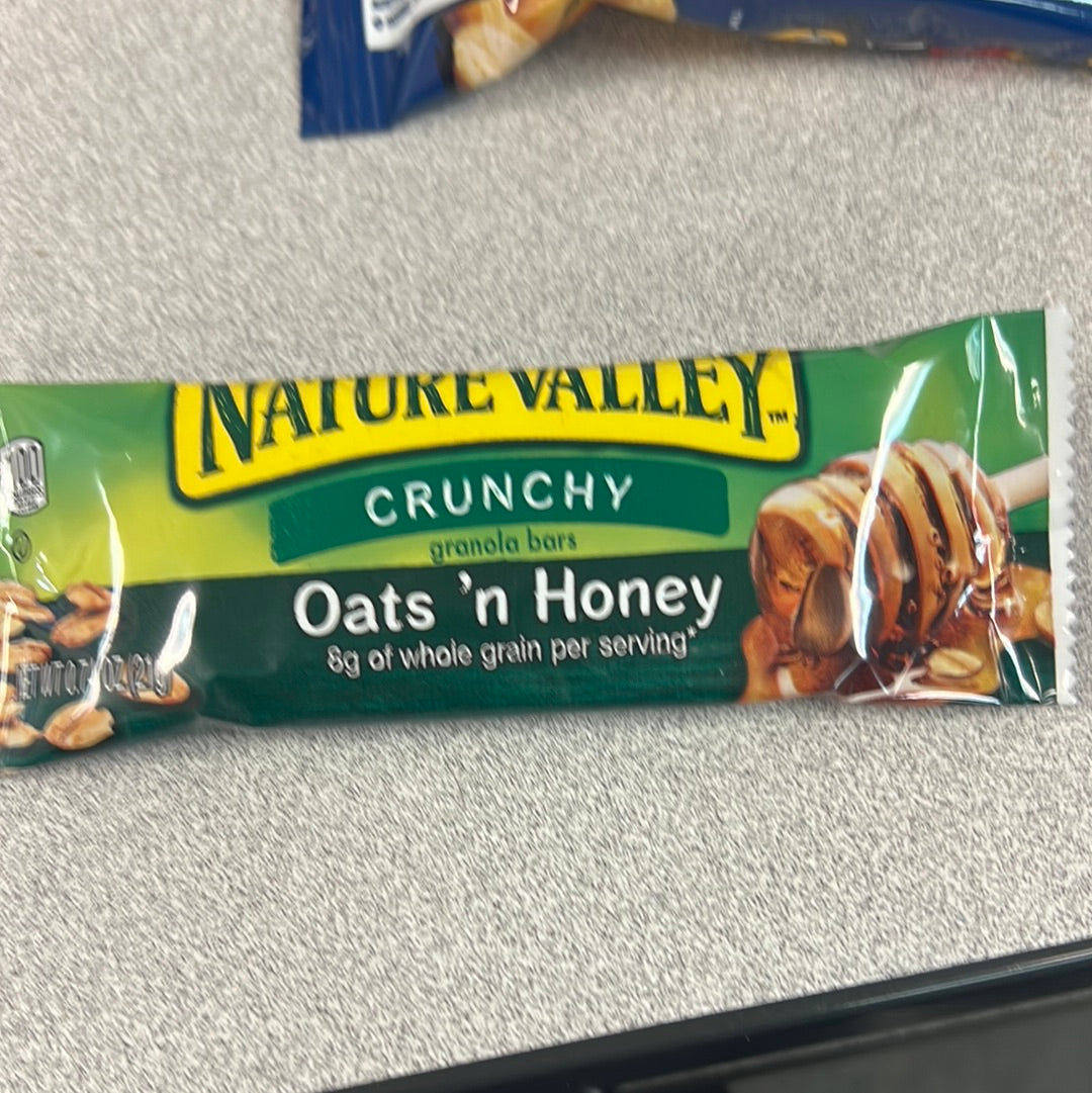 A close-up of Nature Valley Oats ‘n Honey granola bars packaging, showcasing a green and yellow design.