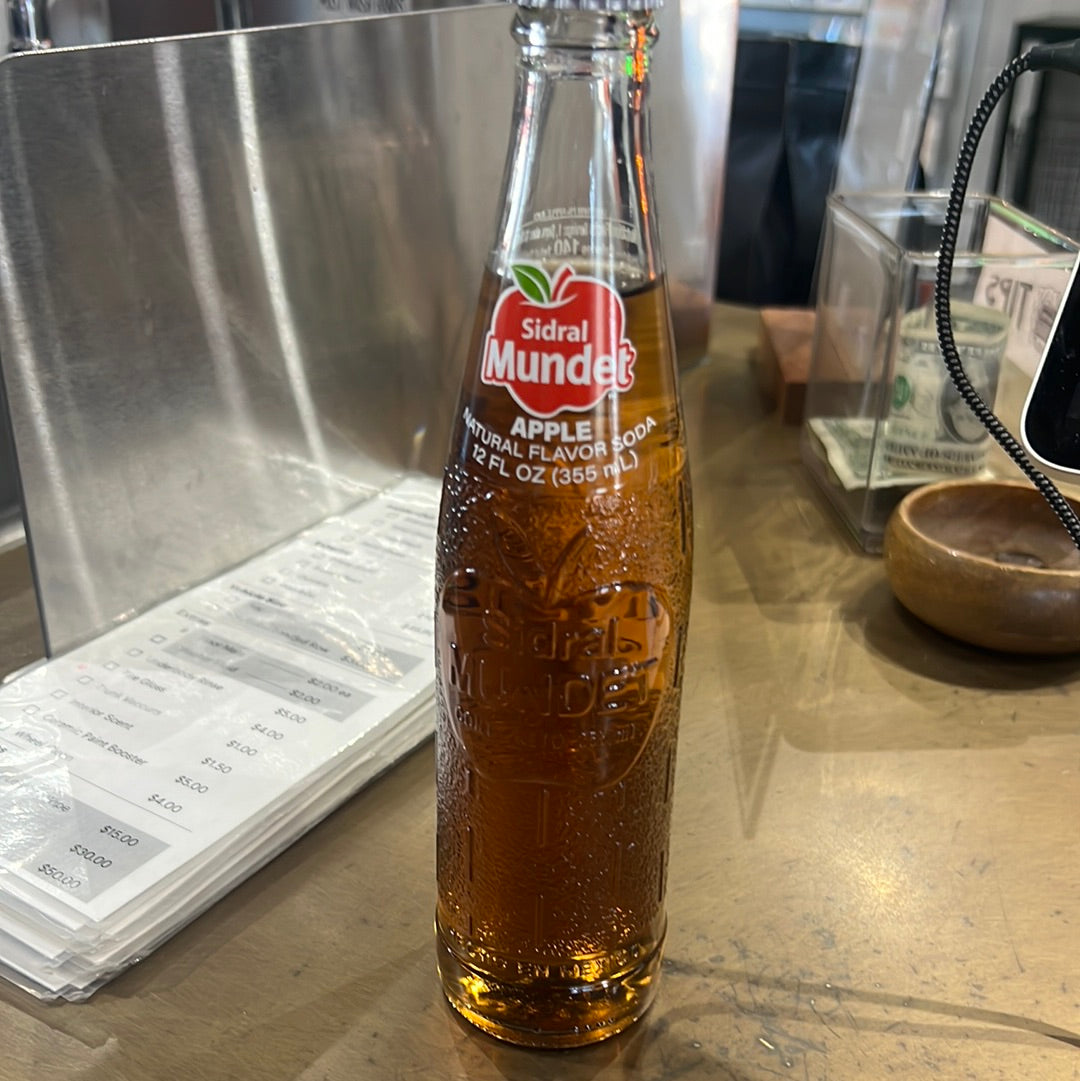 A close-up of Sidral Mundet apple cider in a glass bottle, showcasing its refreshing beverage appeal.