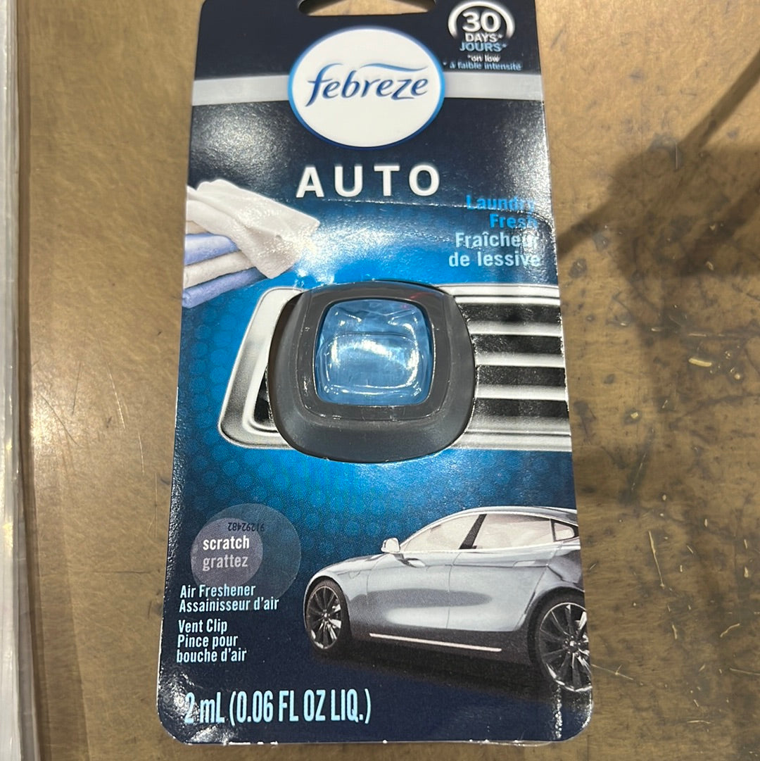 A close-up of a Febreze Car Vent Air Freshener - Laundry Fresh package, featuring a blue and black design, against a backdrop of a car interior.